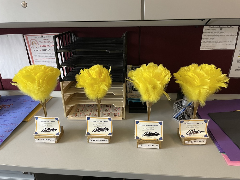 Four Yellow Feather Dusters with award cerfificates attached, one for each grade, Kindergarten, young 5s, 1st grade, and 2nd grade
