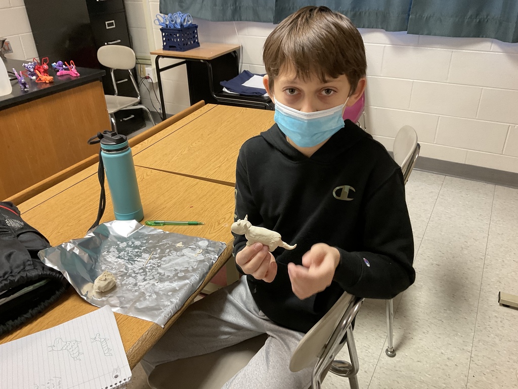7th Grade student preparing to build clay dragon in science class.