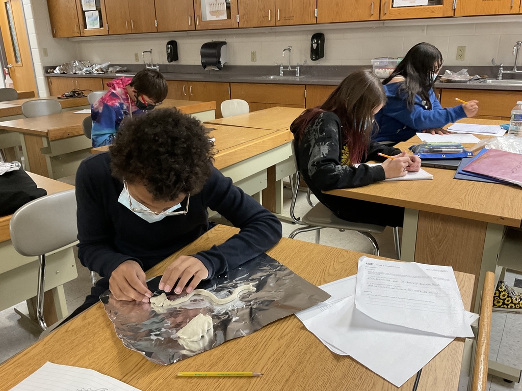 7th Grade student preparing to build clay dragon in science class.