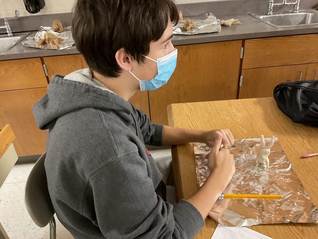 7th Grade student preparing to build clay dragon in science class.