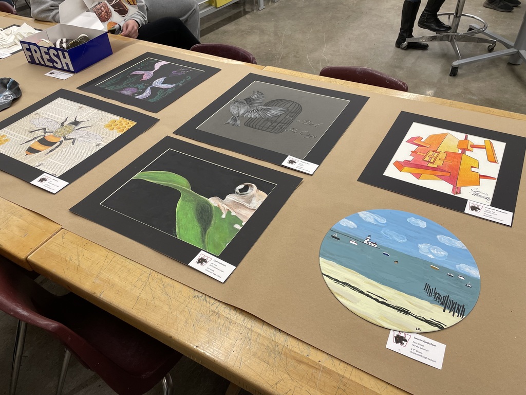 Several art pieces are lying on a table for viewing