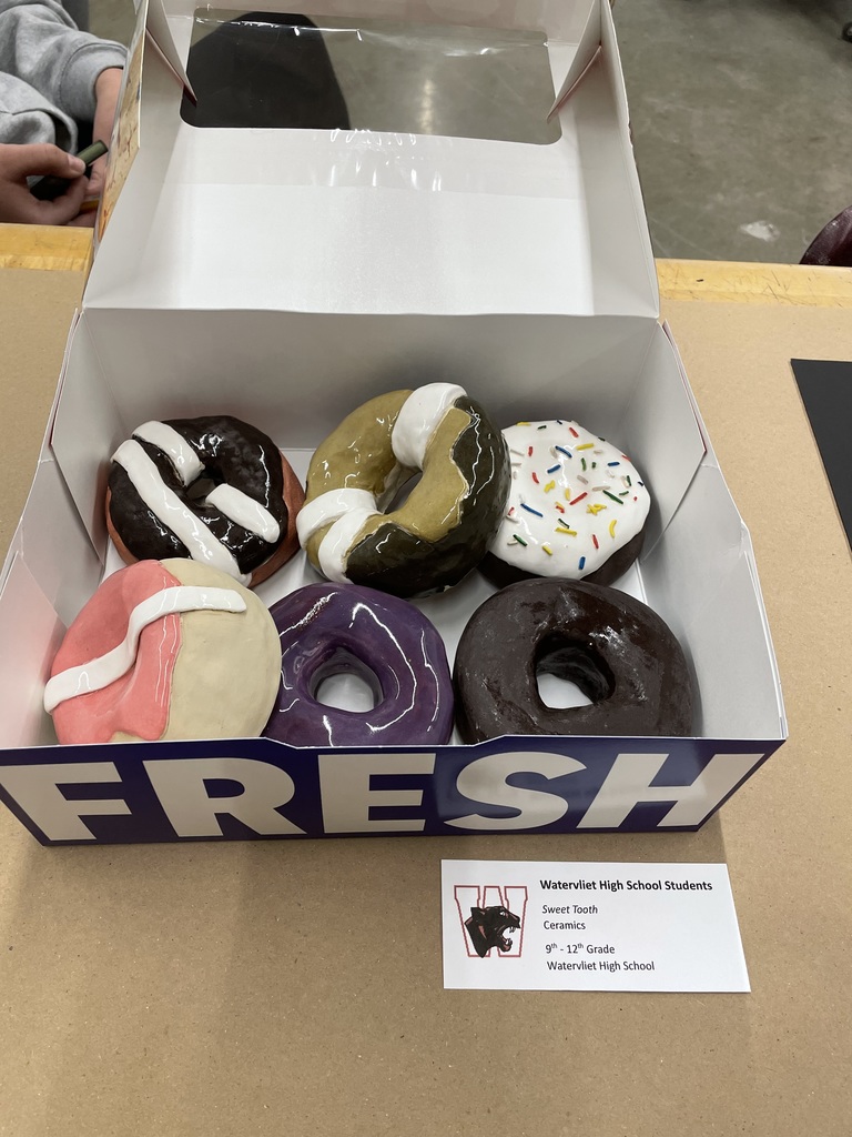 a donut box fille with ceramic donuts sculpted and glazed by WHS art students in 9th - 12th grade.  Titled:  Sweet Tooth, Ceramics