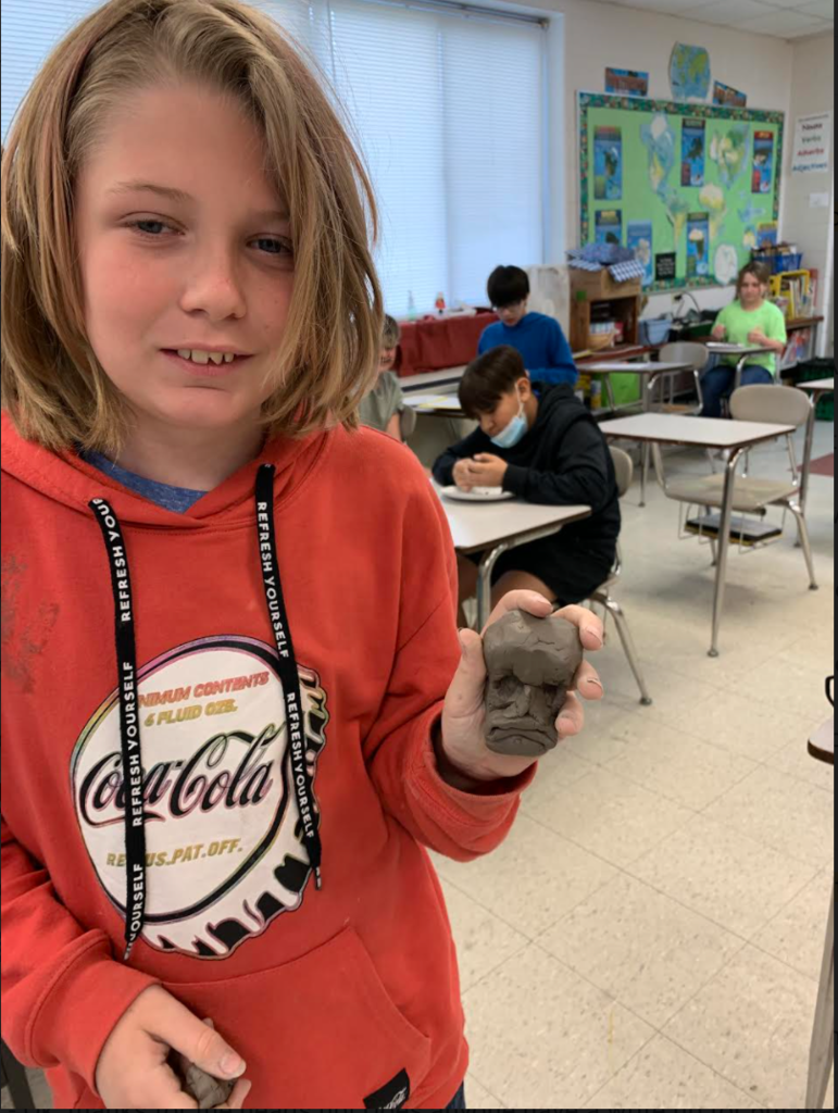 6th grade student with their Olmec statue.