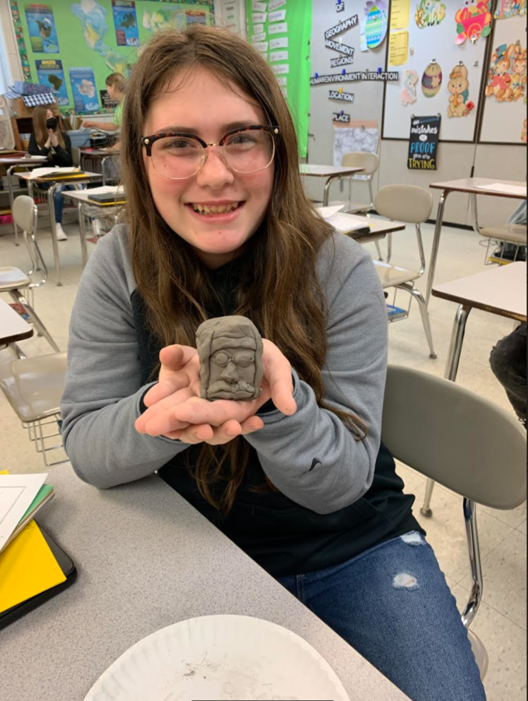 6th grade student with their Olmec statue.