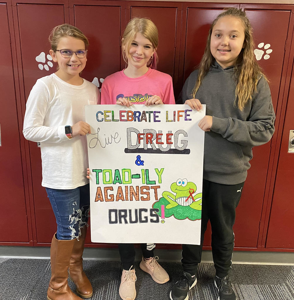 Three middle School age children hold the poster they contributed which won the Red Ribbon Poster Contest.  The poster says Celebrate life - live drug free:  Toad-ly against drugs (there is a picture of a toad).