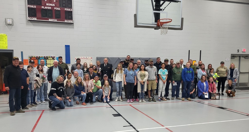 Veterans and Middle School Students stand for a group photo in the WMS gymnasium