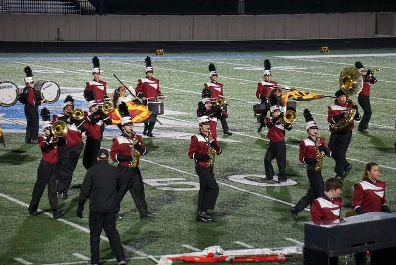 Band members performing their program on the football field